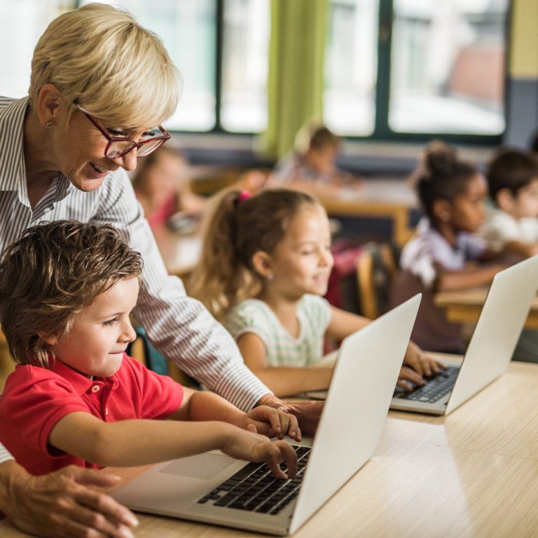 Eine Lehrerin hilft bei der Arbeit am Computer.