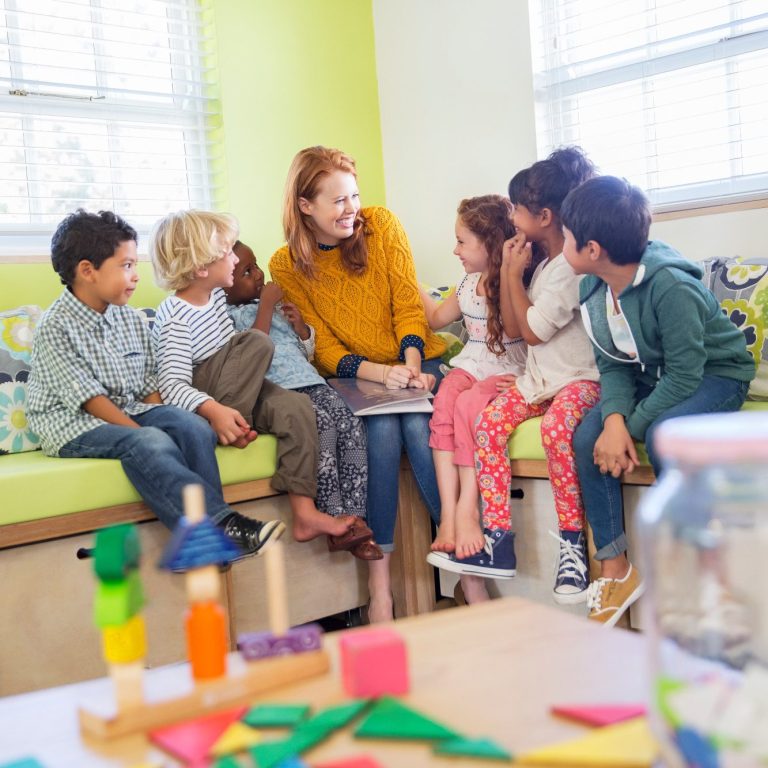 Erzieherin und Schülerinnen sprechen miteinander.