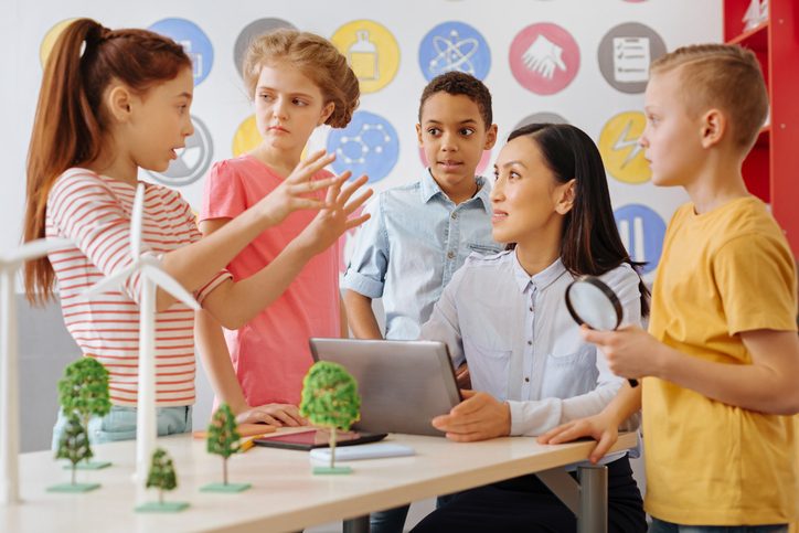 Eine Lehrerin spricht mit Kindern im Unterricht.