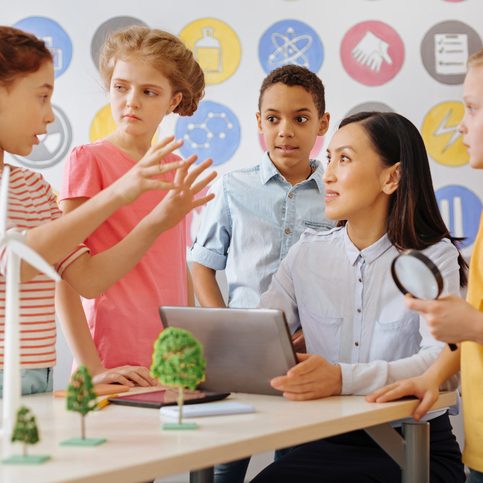 Eine Lehrerin bespricht mit Kindern ein Projekt.