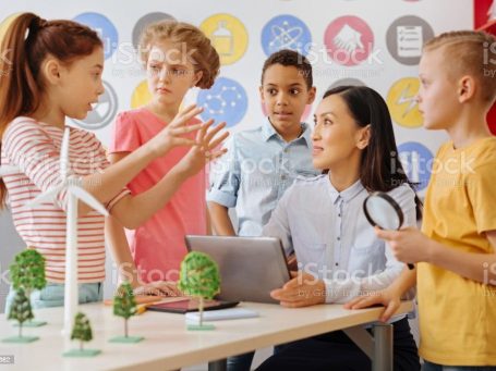 Eine Lehrerin bespricht mit Schülern ein Projekt.